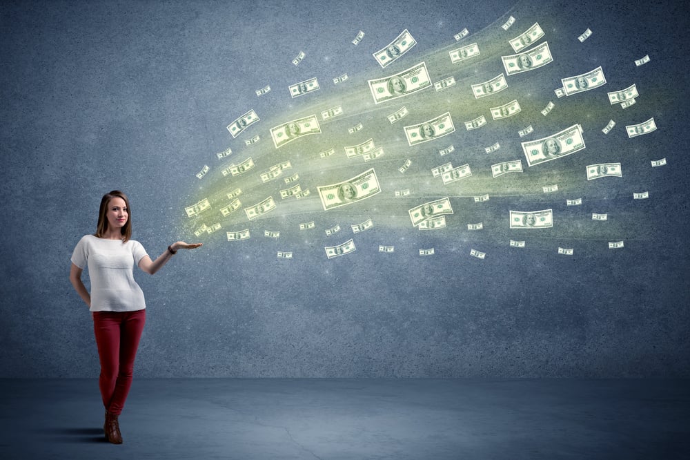 Caucasian woman holding money, which flies from her hands